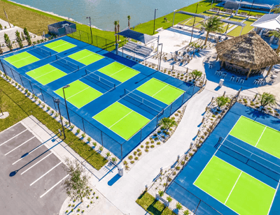 aerial of bright green and blue pickleball courts at The Surf RV Resort