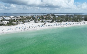 a beach with many people and umbrellas