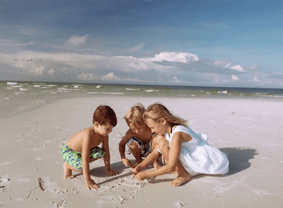 kids searching for shells in the sand