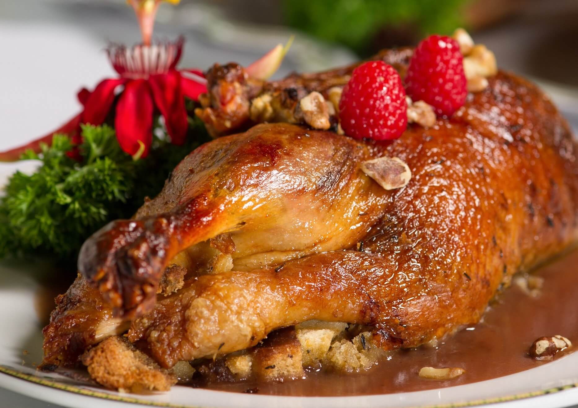 a roasted chicken with raspberries and nuts