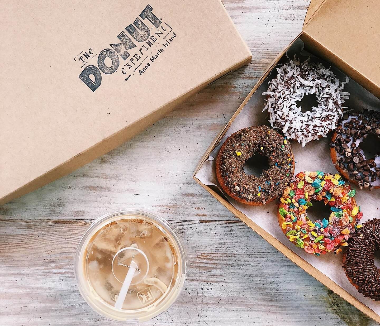 a box of doughnuts and an iced coffee