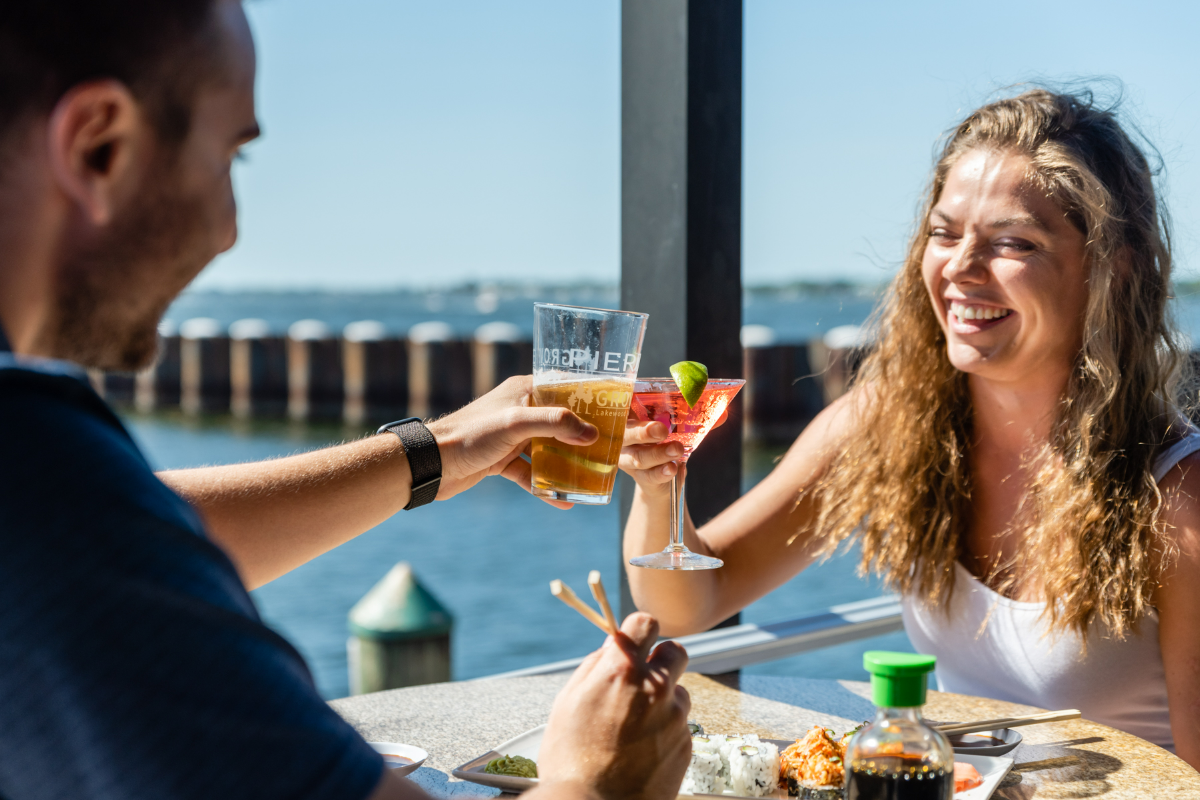 two people cheersing drinks at Pier 22 with a view of the Manatee River
