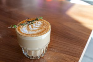 a glass of coffee with a leaf design on top