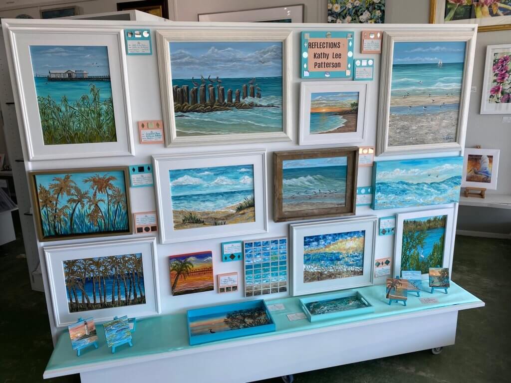 various framed paintings of scenes around anna maria island