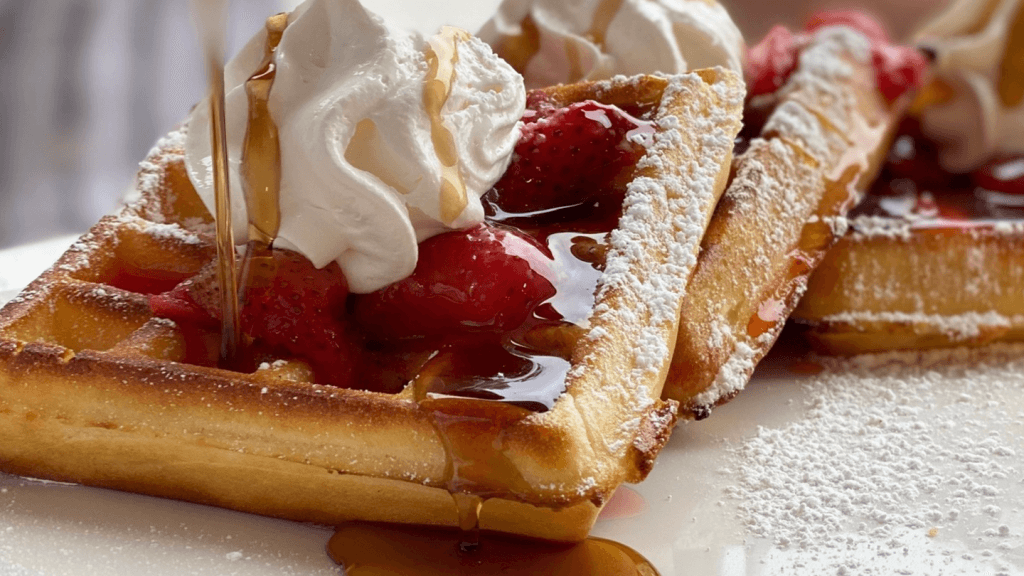 a waffle with strawberries and whipped cream