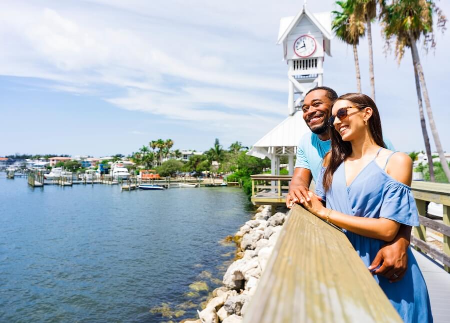 a man and woman standing on a railing by water