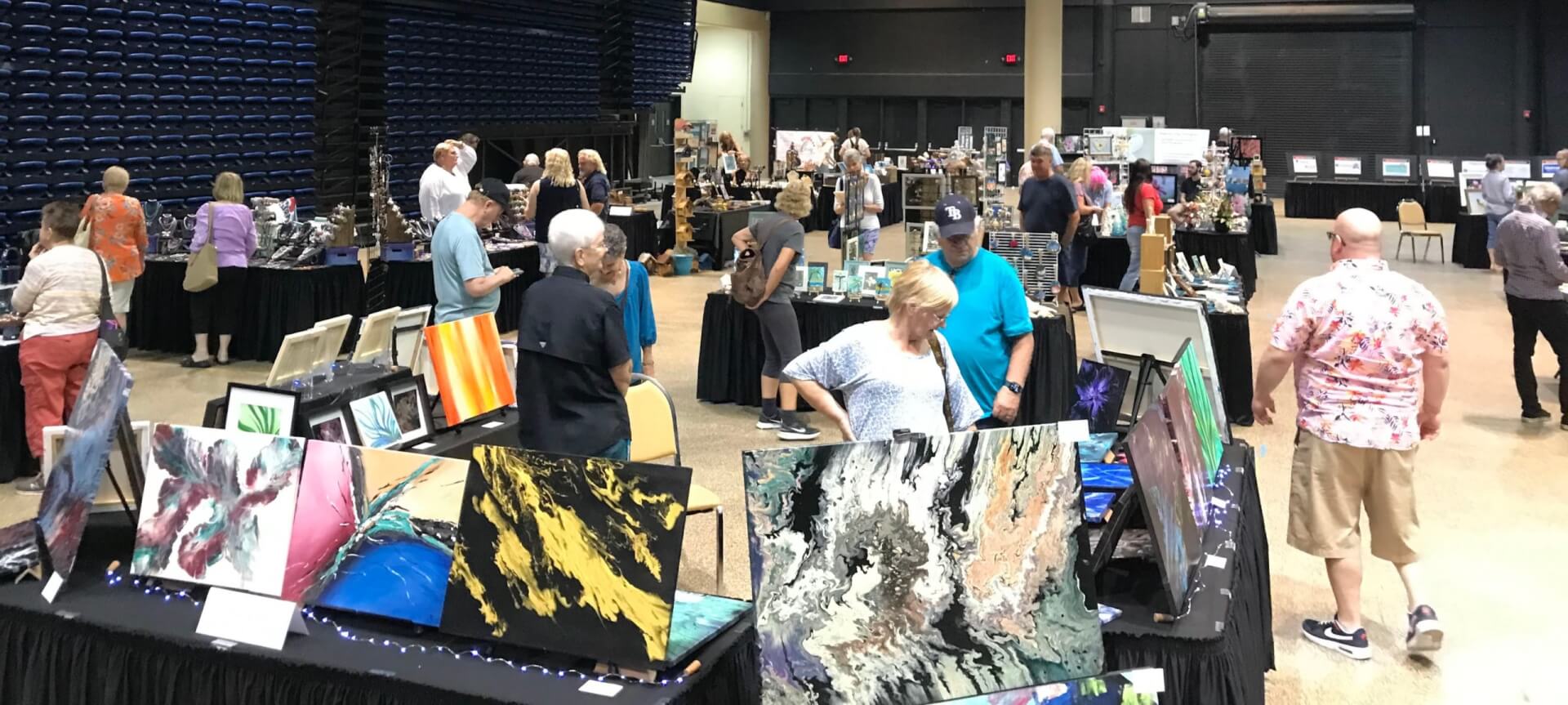 a group of people in a room with art and paintings