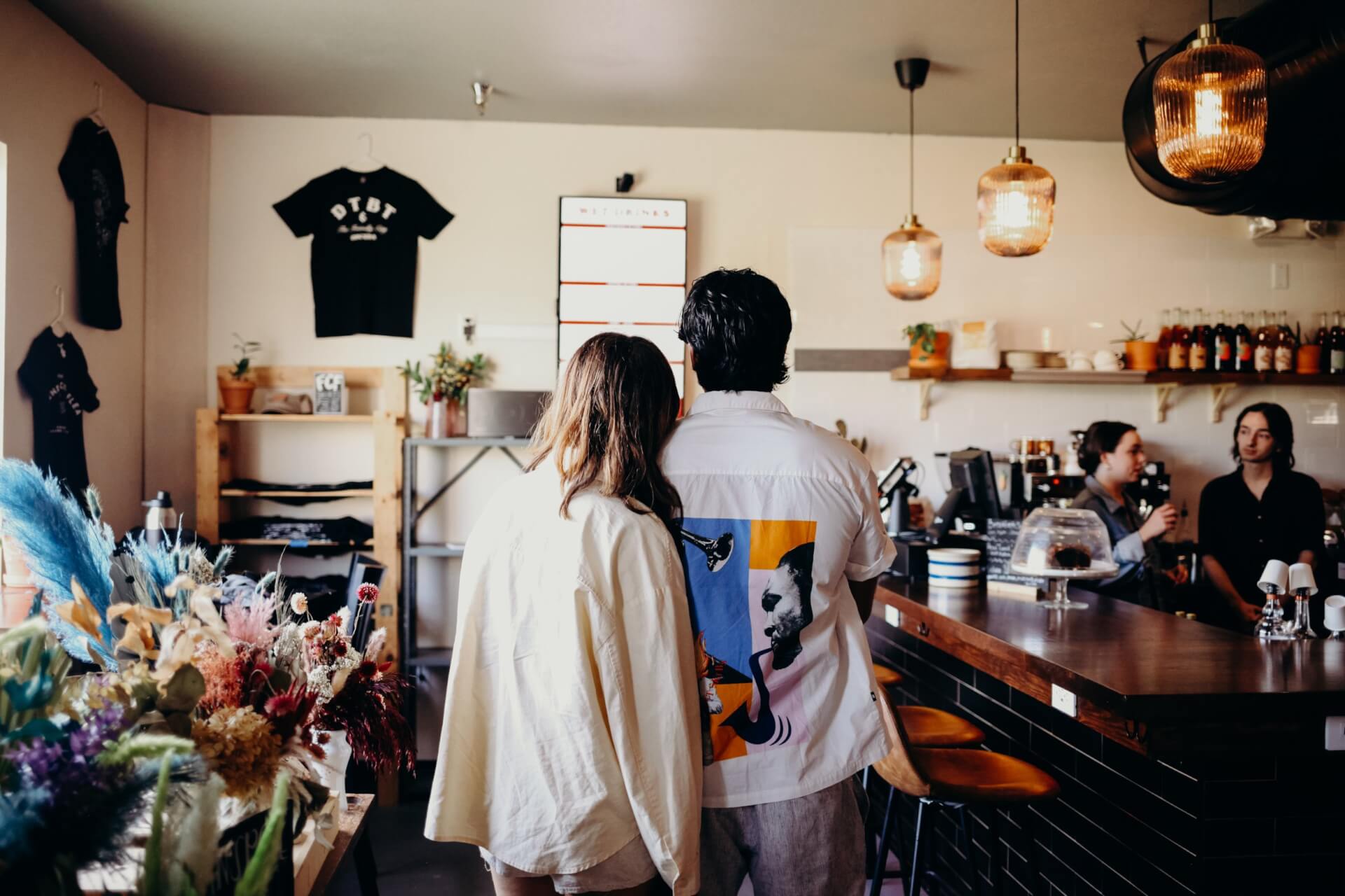 a man and woman standing in a cafe