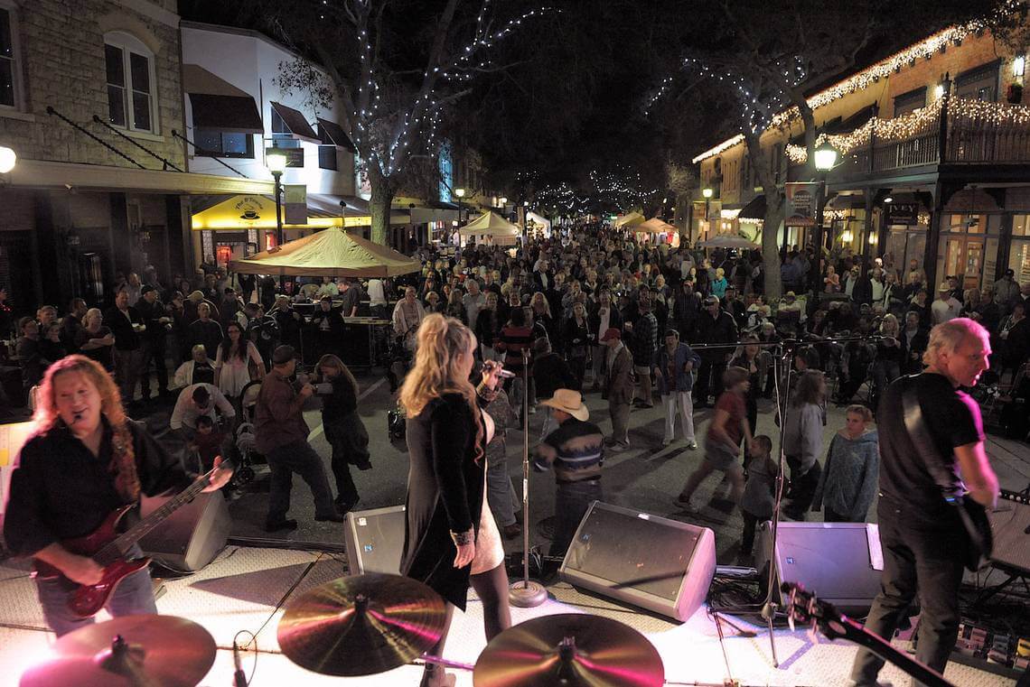 a woman performing on a stage with a crowd of people