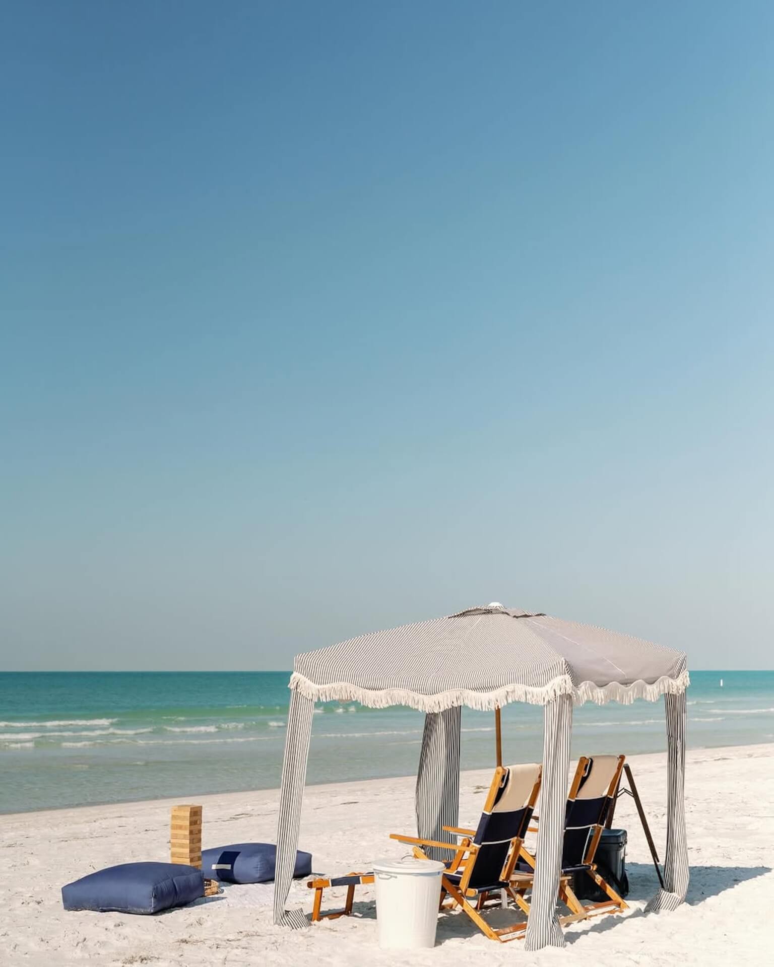 a beach with chairs and a tent