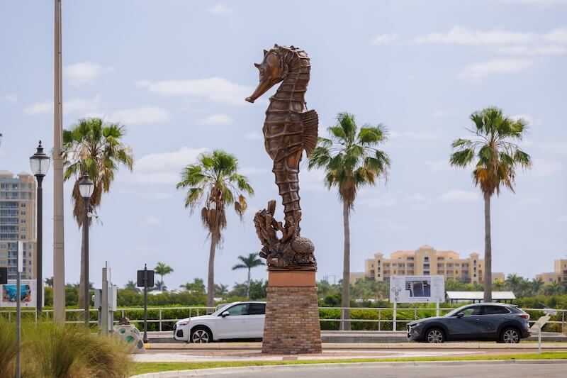 large metallic sculpture of a seahorse on a sunny day